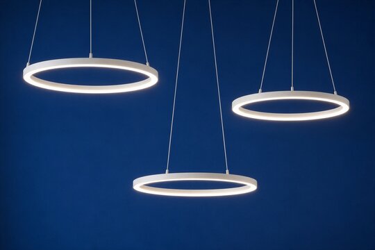 Pendant ring lights suspended over dark blue background