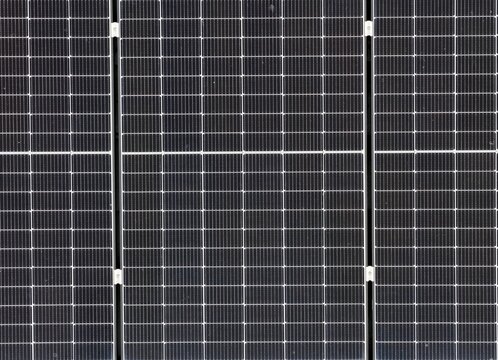 Aerial view of a residential house roof with installed solar panels for renewable energy power. A top down perspective of a tiled roof featuring multiple photovoltaic modules capturing sunlight