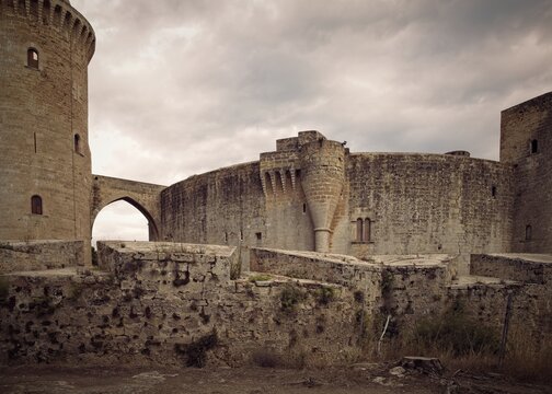Historic Bellver Castle round tower against a dramatic stormy sky in Mallorca, Spain