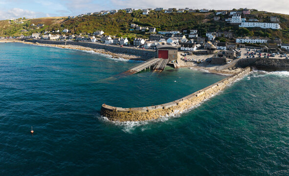 Aerial landscape from the sea of the Cornish village of Sennen Cove in Cornwall, UK at sunset