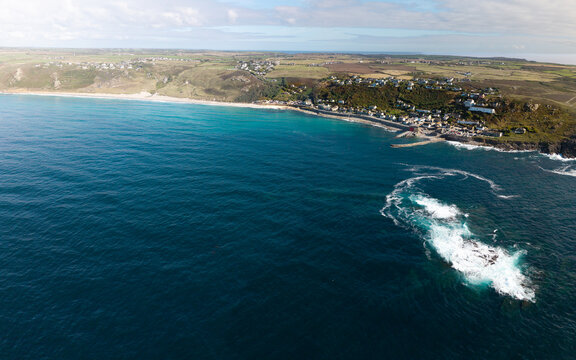 Aerial landscape from the sea of the Cornish village of Sennen Cove in Cornwall, UK at sunset