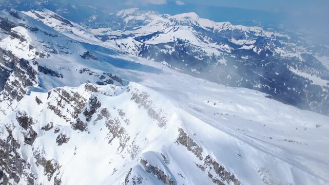 Aerial flight along a snowy ridge above Lake Walen in Switzerland