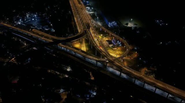 Cinematic aerial drone footage of Atal Setu, also known as Mumbai Trans Harbour Link, illuminated at night, capturing its sweeping sea bridge, interconnected highway ramps, Mumbai Harbour.