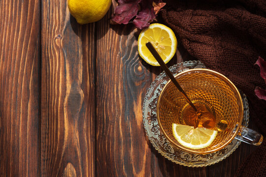 Warm Honey Lemon Tea Served in Ornate Glass Cup on Rustic Wooden Tabletop