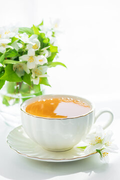 A Delicate White Cup of Herbal Tea With Fresh Jasmine Flowers and Green Leaves