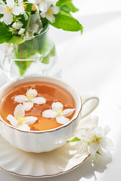 Fragrant jasmine tea in elegant white cup with fresh blossoms infused for refreshing beverage experience