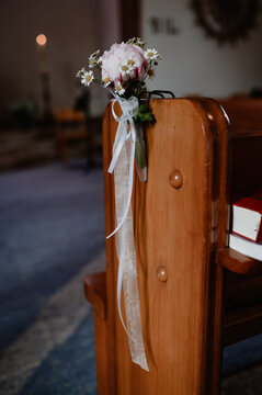 Bridal bouquet on a church pew as wedding decoration