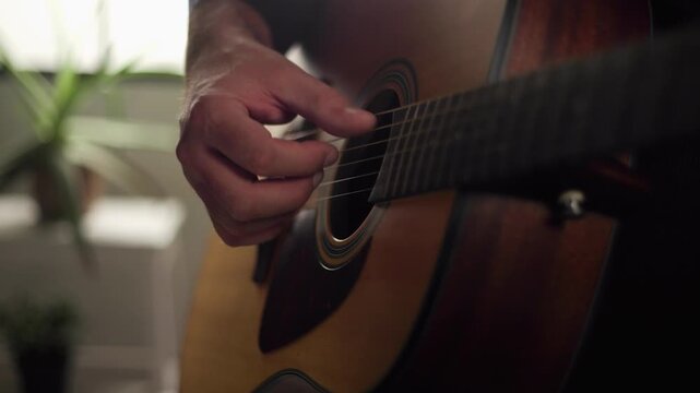 Music therapy and creative expression, person playing acoustic guitar in a home studio, close up shot of hands strumming strings for relaxation and hobby concepts
