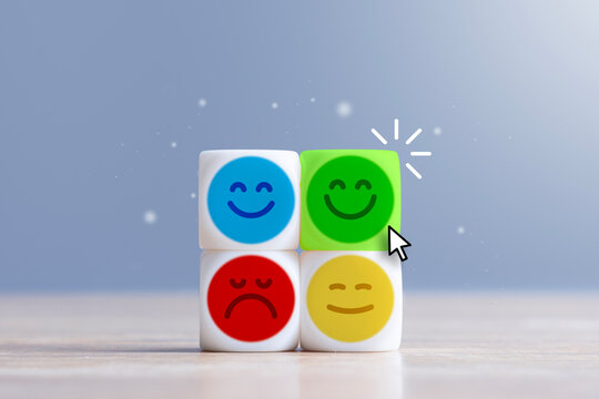 Mouse cursor selecting glowing green happy emoticon cube among neutral and sad faces. Customer satisfaction rating, user experience feedback, net promoter score survey and service review concept.