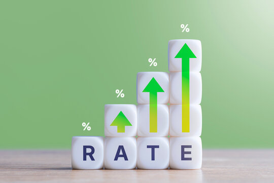 Rising green arrows and percent signs on white cubes forming word RATE over green background. Interest rate increase, inflation growth, financial return and central bank hike concept.