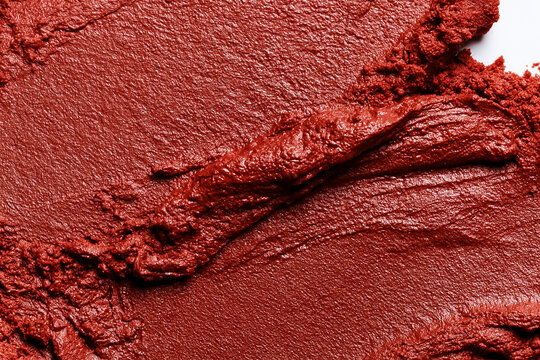 Macro close up of a burgundy red lipstick cosmetic product smear with a textured, creamy surface, perfect for beauty concepts