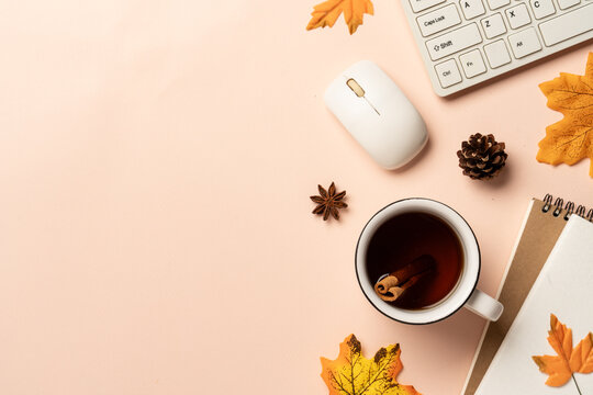 Autumn workspace flat lay background. Laptop, notebook, mug of spicy tea and scarf with yellow leaves.