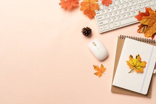 Autumn workspace flat lay background. Laptop, notebook, mug of spicy tea and scarf with yellow leaves.