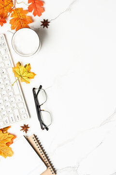 Autumn office desk. Laptop, notebook, cup of coffee and yellow leaves. Flat lay with space for text.