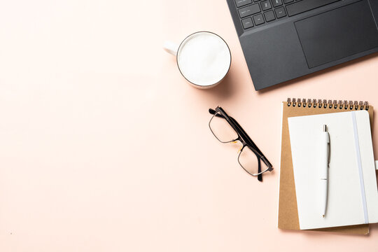 Autumn office desk. Laptop, notebook, cup of coffee and yellow leaves. Flat lay with space for text.