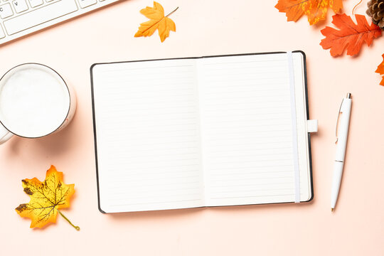 Autumn workspace. Notebook, cup of coffee and yellow leaves. Flat lay with space for text.