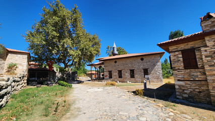 Historic Şaban Ağa Mosque in Eskihisar, Stratonikeia, Yatağan, Muğla, rebuilt in 1876 with an elegant timber-columned prayer porch featuring painted ceiling decorations, adjacent to Roman ruins and th © cilicia