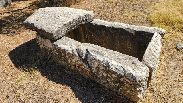 A roughly carved stone sarcophagus and lid in the necropolis of Stratonikeia Ancient City, Yatağan, Muğla, reflecting funerary traditions from the Hellenistic period through Roman and Late Antique tim