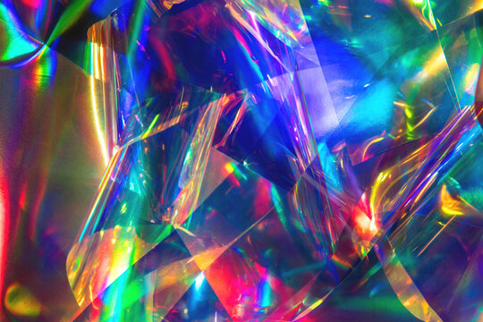 Abstract holographic foil background with overlapping translucent shards in a rainbow spectrum of violet, cyan, and magenta. Drops into a psychedelic fashion and album cover composition.