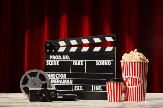 Cinema and film production movie industry entertainment with clapperboard vintage camera popcorn and drink on a red theater curtain background