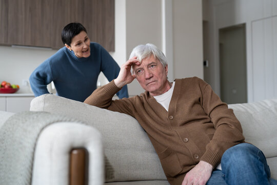 Stressed unhappy senior husband tolerating annoyed and frustrated wife during marital quarrel, elderly man with fatigue and apathy listening to continuous blaming and arguments from aged woman.