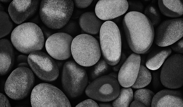 Abstract background textured with smooth, black round, wet pebbles. close-up sea beach with pebbles for website banner template page design.