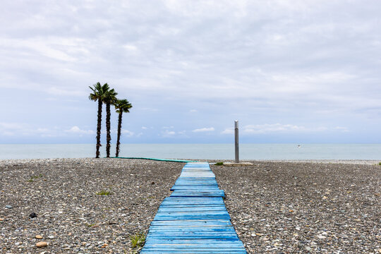 pebble beach with blue wooden boardwalk in Batumi