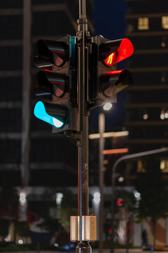 Red and green traffic signals illuminated at night against a softly blurred urban background, representing traffic control, transportation, safety and stop-and-go concepts.