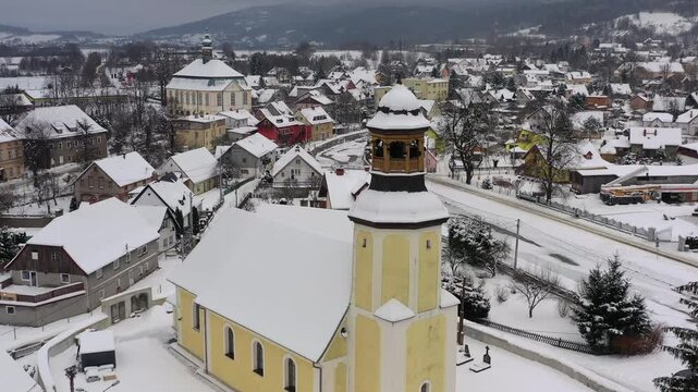 Aerial pullback from Holy Trinity Church over snowy Podg&oacute;rzyn village