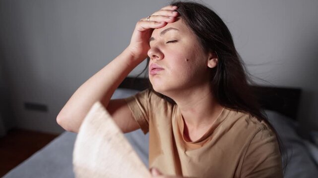 Young woman struggles with oppressive heat and difficult breathing while sweating heavily. Slow motion footage captures physical discomfort during extreme summer temperatures.