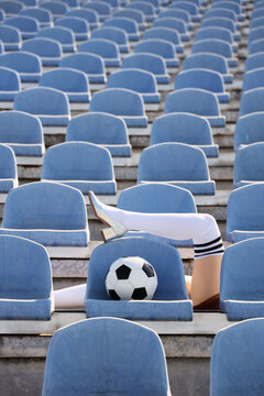 Sports fashion and femininity, woman legs in high heels and soccer socks with ball in empty stadium seats for creative advertising and lifestyle