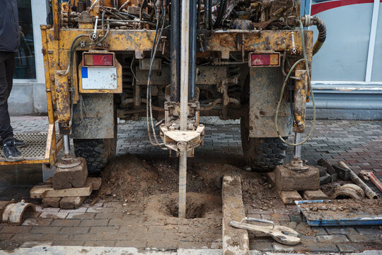 Drilling rig creates borehole at construction site for geotechnical soil and foundation engineering investigation in urban environment