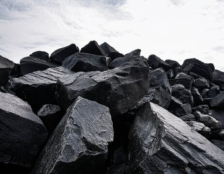 dark rugged angular rocks form a sprawling pile in the lower frame their textured surfaces sharply contrasting