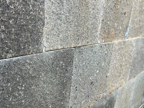 Rough grey basalt stone wall tiles texture perspective view photo