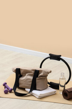 Fitness and wellness routine, gym bag with pilates ring and dumbbells on yoga mat for healthy lifestyle and active living in home workout environment