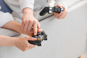 Family bonding and leisure time, parent and child playing video games together at home with game controllers for entertainment and digital recreation © Pixel-Shot