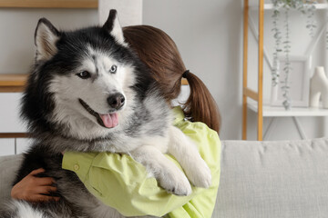 Pet companionship and emotional support, woman hugging her husky dog at home for mental health and friendship in a cozy living room environment © Pixel-Shot