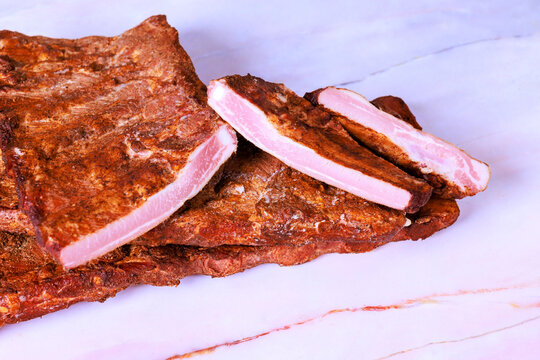 Slices of dried smoked ribs meat are on counter ready for use in meals snacks.