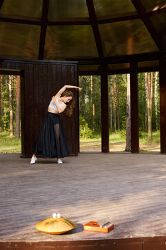 Focused ballet dancer rehearsing on wooden platform before performance