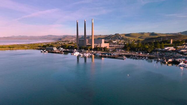Aerial footage of Morro bay with three smokestacks at sunrise, California.