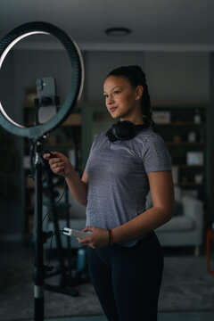 Woman content creator adjusting ring light preparing for live stream