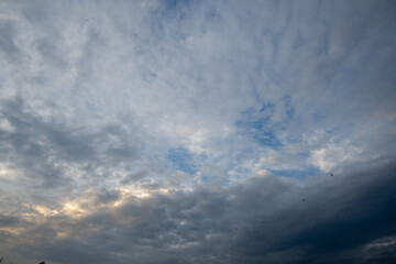 Obraz premium Moody blue and gray cloudy sky with soft morning light breaking through