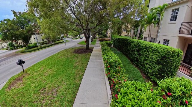 Smooth 4K walking tour passes lush landscaping and multistory homes with garages in Naples, Florida.
