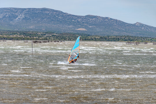 Kitesurfing and powerful Tramontane wind sweeps across &Eacute;tang de Salses-Leucate, creating waves, spray, and  dramatic Mediterranean landscape in Occitanie, France