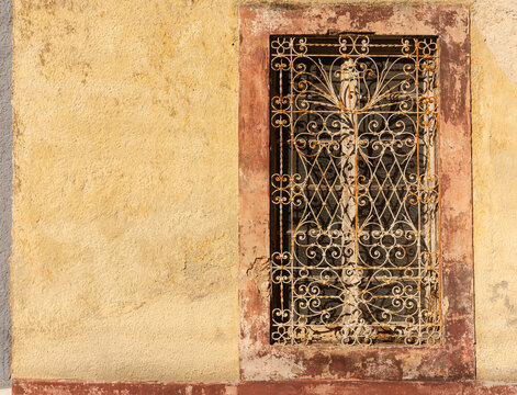 old window in the old building with interesting iron scroll work in Mexico