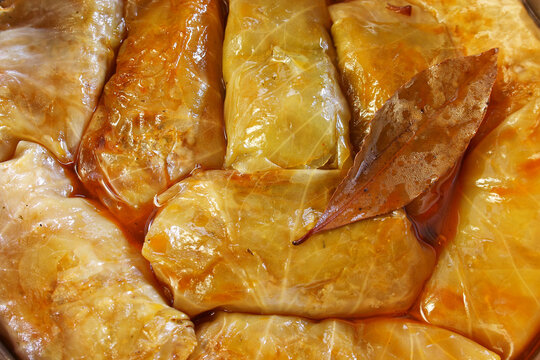 Sarma - traditional Croatian stuffed cabbage rolls. 
A detailed close-up photography of traditional stuffed cabbage rolls (sarma) tightly packed together.