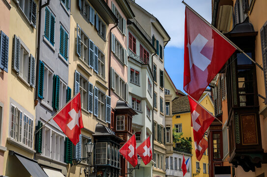 Swiss flags hang from the historic buildings in the Old Town, Zurich Switzerland