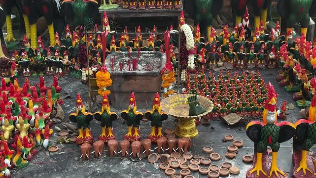 Rooster figurines and offerings at shrine in Chiang Mai