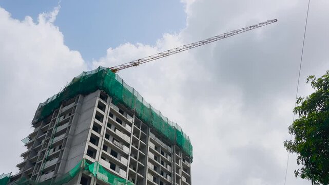 Tower Crane Above Building Under Construction with Upward Camera Tilt