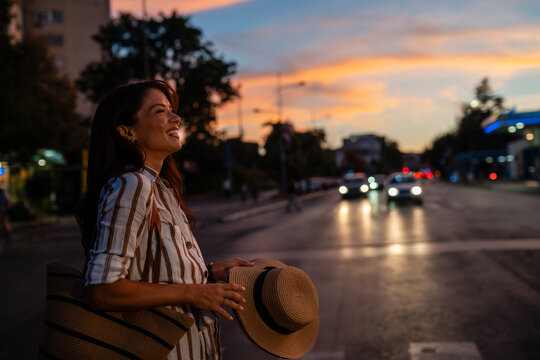Woman enjoying urban sunset feeling happiness and freedom